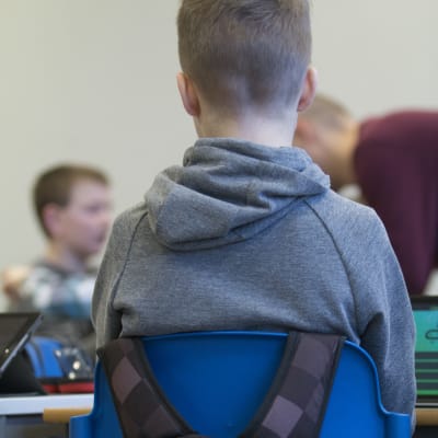 Pojke sitter i klassrum