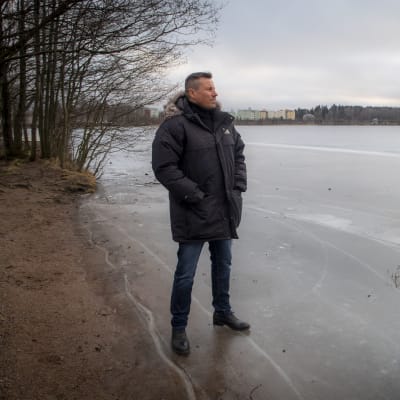 Harri Gustafsberg seisoo jäätyneen Tohlopinjärven rannalla