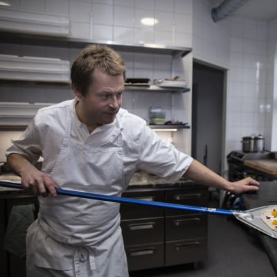 Restaurangägare Nick Victorzon skyfflar in en pizza i ugnen.