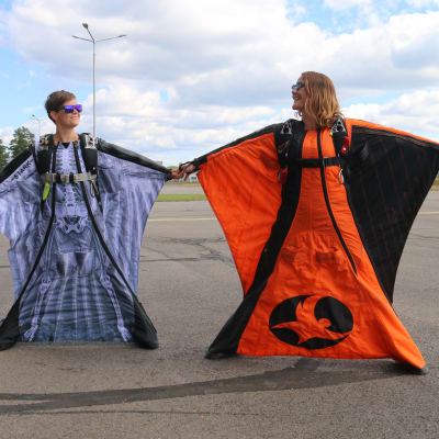 Laskuvarjohyppääjät Pilvi Juvonen ja Faye Lawson esittelevät liitopukua Utin lentokentällä