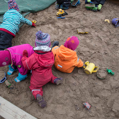 Barn leker i sandlåda