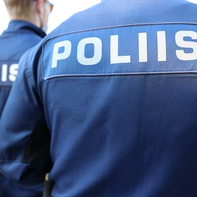 Ryggarna på poliser där det på finska står poliisi.