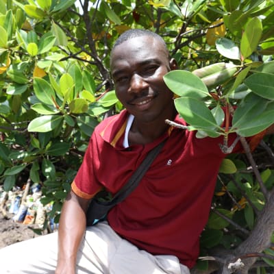 Mbaarak Abdalla bland mangroveträd han varit med om att plantera för att rädda mangroveskogarna utanför Mombasa.