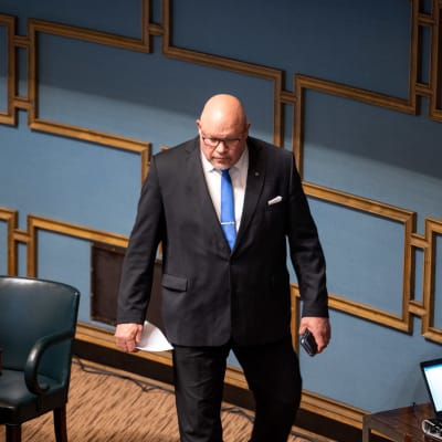 Ano Turtiainen i kostym i riksdagens plenisal.