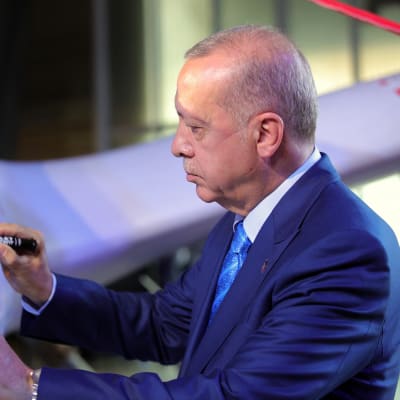 Recep Tayyip Erdogan skriver sitt namn på en turkisk drönare.  