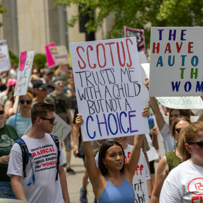 Kvinnor håller upp skyltar under abortdemonstration.