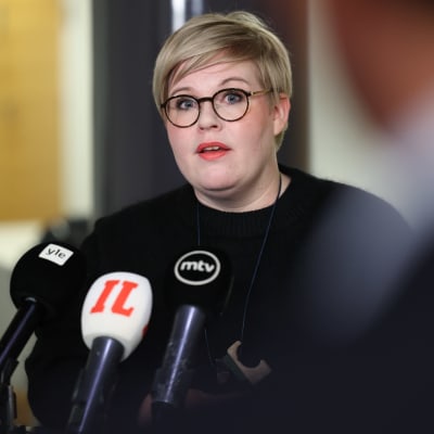 Annika Saarikko framför mikrofoner.