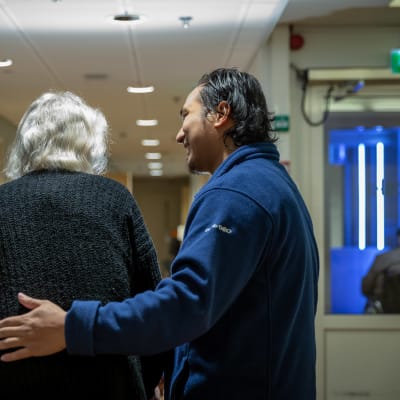 Närvårdare Bern Amar hjälper en äldre år 2018.