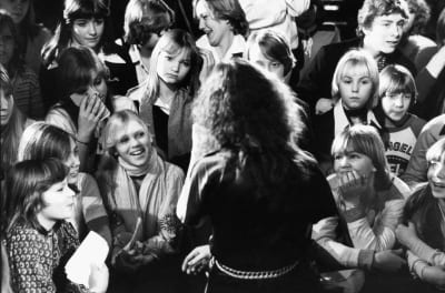 Anni-Frid från ABBA omringad av unga fans i Stockholm 1988. Hon har ryggen mot på bilden.