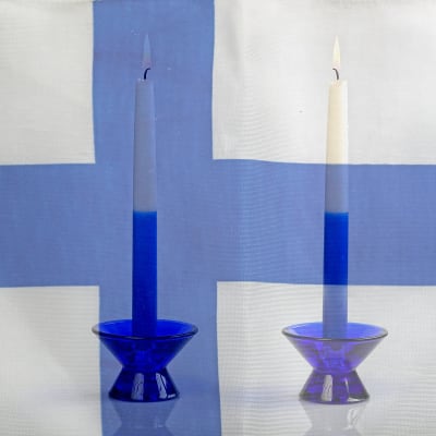 Två blåvita ljus mot en finlandsflagga.