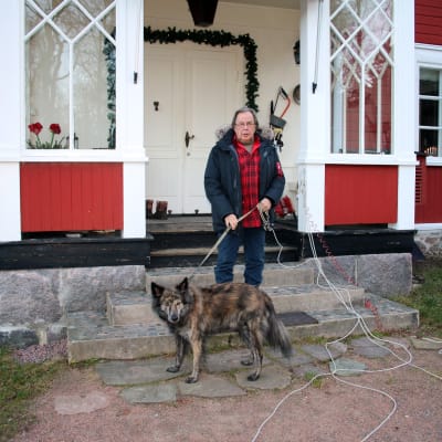 Cay Karlsson framför huset i Bromarf med hunden Nasti