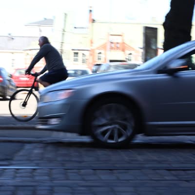 En bil kör nära en cyklist.