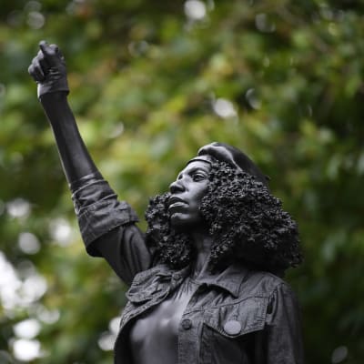 Mustaa naista esittävä patsas. Naisen käsi on nyrkissä.