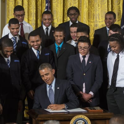 US President Barack Obama, surrounded by students from a Chicago youth guidance program called Becoming A Man, signs a Presidential Memorandum, called the My Brother's Keeper Task Force, in the East Room of the White House in Washington, DC, USA, 27 Febru