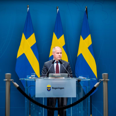Morgan Johansson med Sveriges flaggor i bakgrunden.
