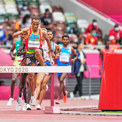 Yemane Haileselassie hoppar över ett hinder i OS i Tokyo.