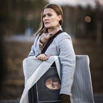 Lea (Pirjo Lonka) står med en Kristustavla under armen och ser bekymrad ut.