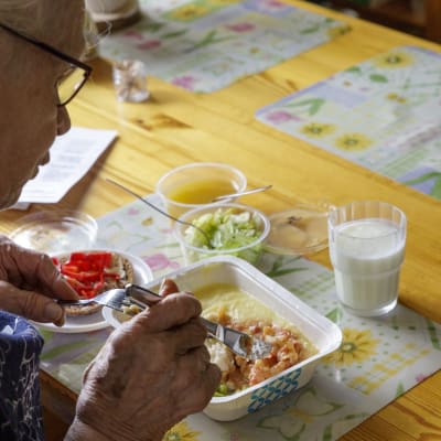 Leena Pulkkinen syö hyvinvointialueen ateriapalveluiden ruokaa omassa keittiössä.