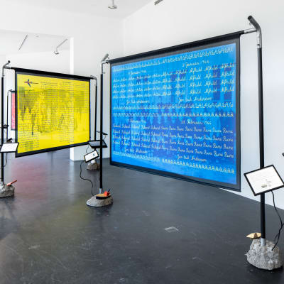 Konstverk i galleri, med stora skärmar i gult och blått.