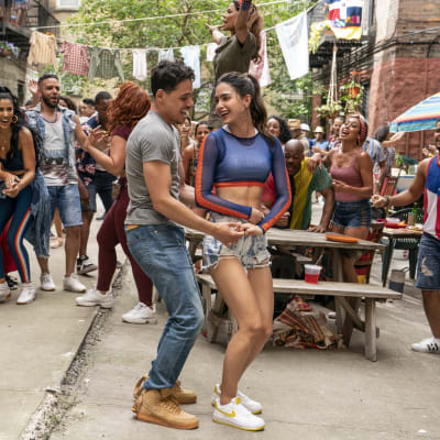 Usnavi (Anthony Ramos) och Vanessa (Melissa Barrera) dansar tillsammans omringade av en massa människor.