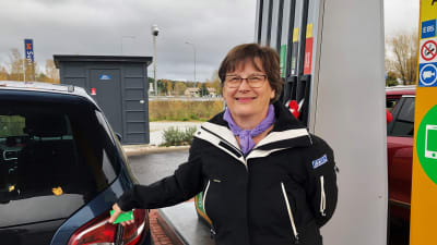 Tove Boström stär bredvid sin bil på en bensinstation.