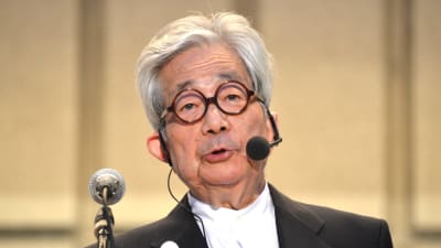 Kenzaburo Oe håller ett tal, iförd headset. 