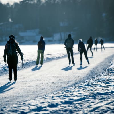 Ulkoilijoita luistelemassa meren jäällä.