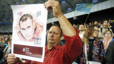 En ukrainsk man håller under fotbolls-VM i Ryssland upp en bild på den fängslade ukrainska filmregissören Oleg Sentsov. 