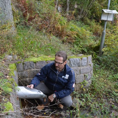 Olav Granström sitter vid ett vattenrör