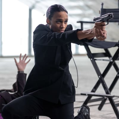 Sylvia Madsen (Nanna Blondell) siktar med en pistol.