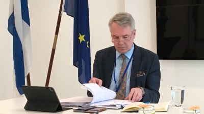 Pekka Haavisto bläddrar i sina anteckningar inför en presskonferens i Bryssel måndagen den 22 mars. 