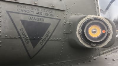 Detalj på sidan av en amerikansk Apache-helikopter, Danger, danger, danger, står det.