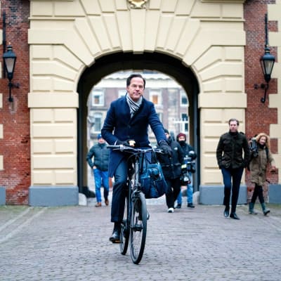 Mark Rutte ajaa polkupyörällä omena kädessään.