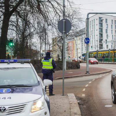 Polis övervakar trafiken vid Mechelingatan i Helsingfors.