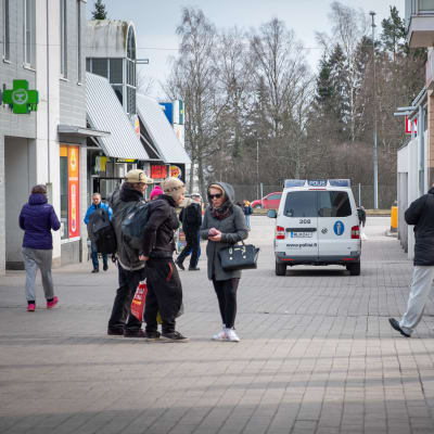 människor och en polisbil står vid köpcentret i Gårdsbacka. 