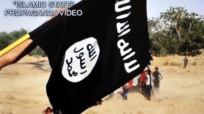 Svart flagga med arabisk text vajar i IS-propagandafilm.