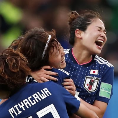 Hinata Miyazawa firar ett mål med två lagkamrater.