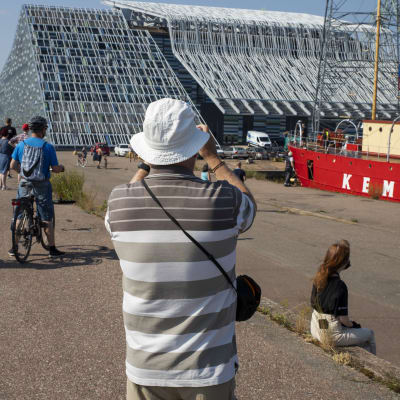 ihmisiä on tullut katsomaan ja ottamaan kuvia majakkalaiva Kemistä Kotkan kantasatamaan, taustalla merikeskus Vellamo