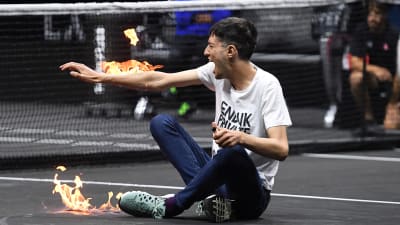 Klimataktivist tuttar eld på sin arm under tennisturnering.