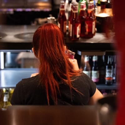 Tarjoilija täyttää kylmäkaappia juomilla ravintolassa.