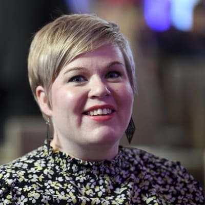 Närbild av ljushårig kvinna som ler. Centerns ordförande Annika Saarikko på Centralhandelskammarens skattedag den 22 september 2021 i Helsingfors.