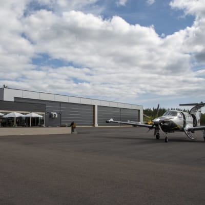 Kaféet, flygplanshallar och ett flygplan på Pyttis flygplats.