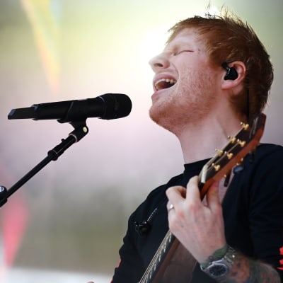 Ed Sheeran spelar gitarr och sjunger på scen.