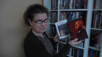 En kvinna visar upp ett par DVD-fodral. Den ena innehåller filmen Shakespeare in love. Den andra tre stycken filmer av Alfred Hitchcock. 