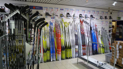skidor och hockeyklubbor står uppradade i en sportaffär