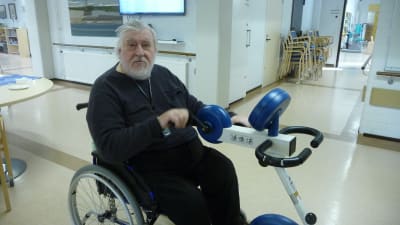 En äldre man sitter i rullstol.