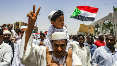 En sudanesisk man med en liten pojke på axlarna under en demonstration i Khartoum på fredagen 12.4.2019.