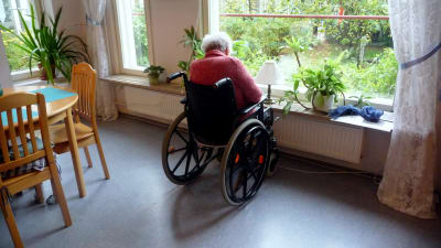 Äldre person i rullstol.