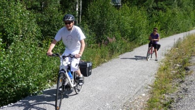 Två cyklister längs med en cykelväg av grus.