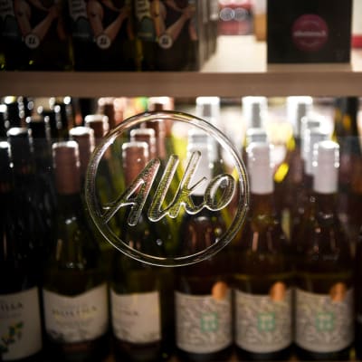 Alkon logo ja viinipulloja kauppahallissa.